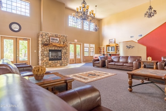 living area featuring an inviting chandelier, french doors, visible vents, and carpet floors