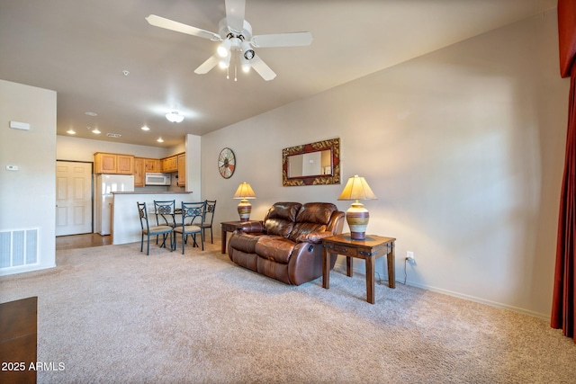 living room with visible vents, baseboards, ceiling fan, light carpet, and recessed lighting