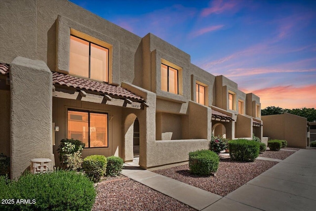 view of front of house featuring a tiled roof and stucco siding
