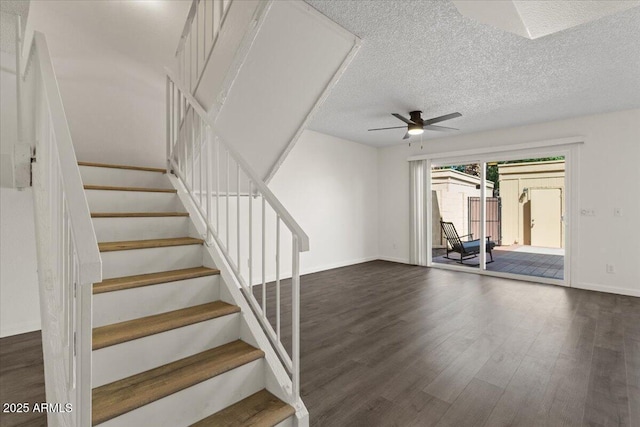 stairs featuring a textured ceiling, wood finished floors, ceiling fan, and baseboards