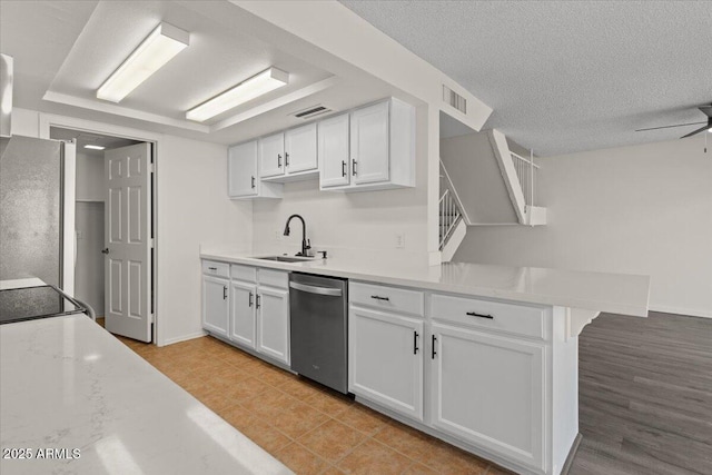 kitchen with a sink, white cabinetry, a peninsula, and stainless steel appliances