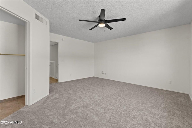 unfurnished bedroom featuring carpet floors, visible vents, and a textured ceiling