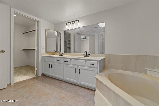 full bathroom with a bath, a sink, a ceiling fan, double vanity, and tile patterned floors