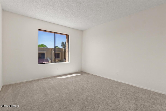 empty room with baseboards, carpet flooring, and a textured ceiling