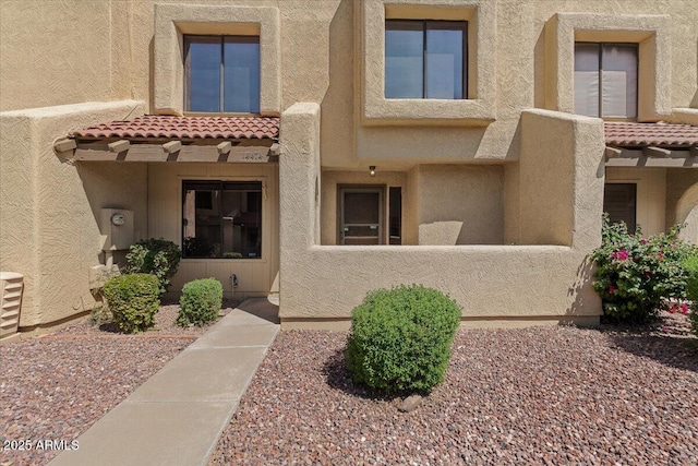 doorway to property featuring stucco siding