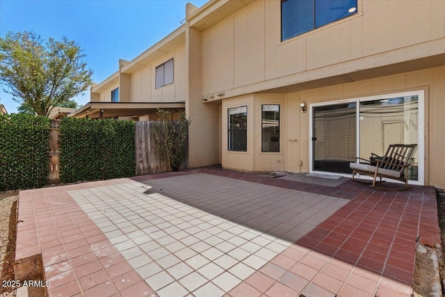 back of property with fence and a patio
