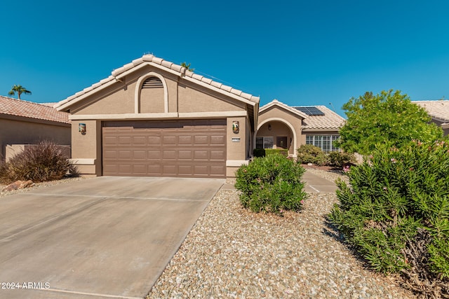 view of front of home with solar panels and a garage