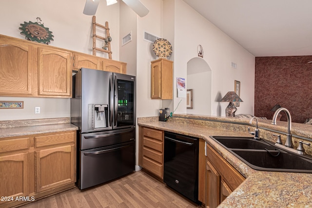 kitchen featuring ceiling fan, sink, black dishwasher, light hardwood / wood-style flooring, and stainless steel fridge