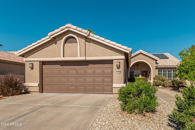 view of front of house featuring a garage and solar panels