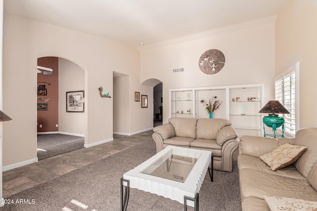 living room featuring carpet and a high ceiling