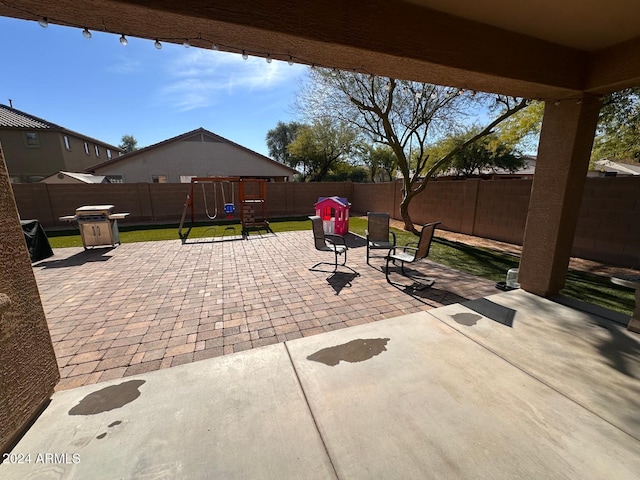 view of patio with a playground and area for grilling