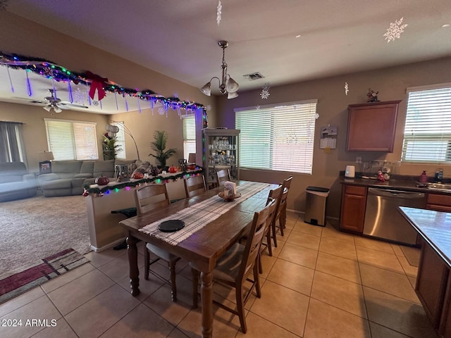 tiled dining area featuring ceiling fan, plenty of natural light, and sink