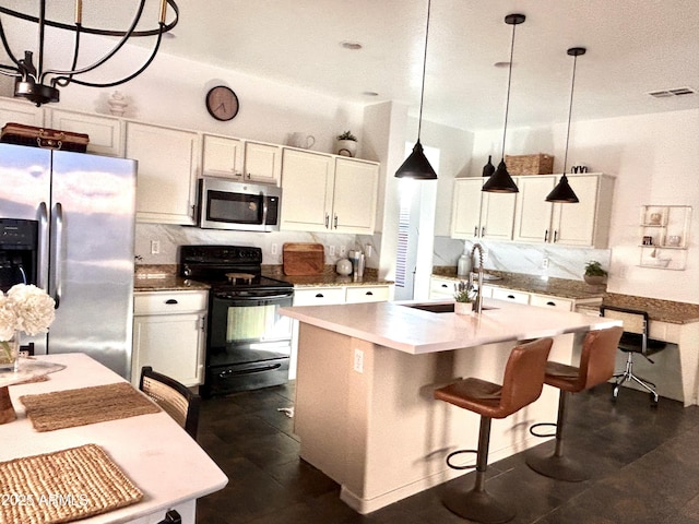 kitchen featuring sink, decorative light fixtures, a center island with sink, appliances with stainless steel finishes, and backsplash