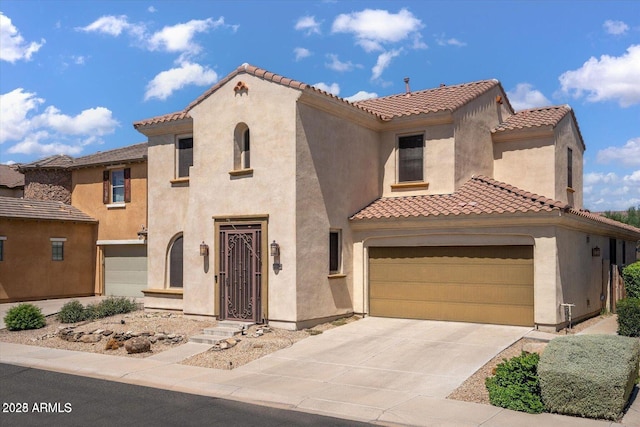 mediterranean / spanish home with driveway, a tiled roof, and stucco siding