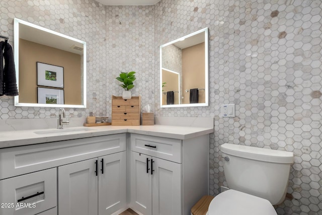 bathroom with tasteful backsplash, vanity, and toilet