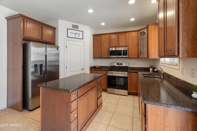 2331 E Sunland Ave, Phoenix, AZ 85040 - kitchen featuring stainless steel appliances, a sink, brown cabinets, dark stone countertops, and recessed lighting