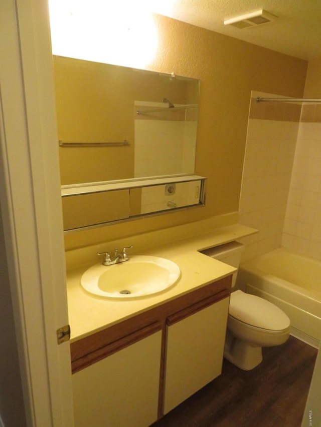 bathroom with vanity, wood-type flooring, a textured ceiling, and toilet