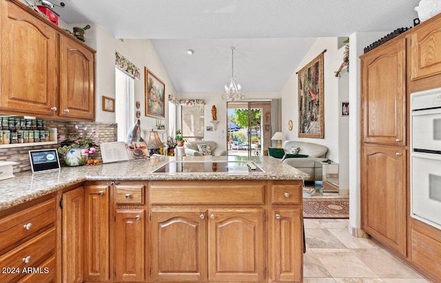 kitchen featuring black electric stovetop, tasteful backsplash, lofted ceiling, hanging light fixtures, and an inviting chandelier