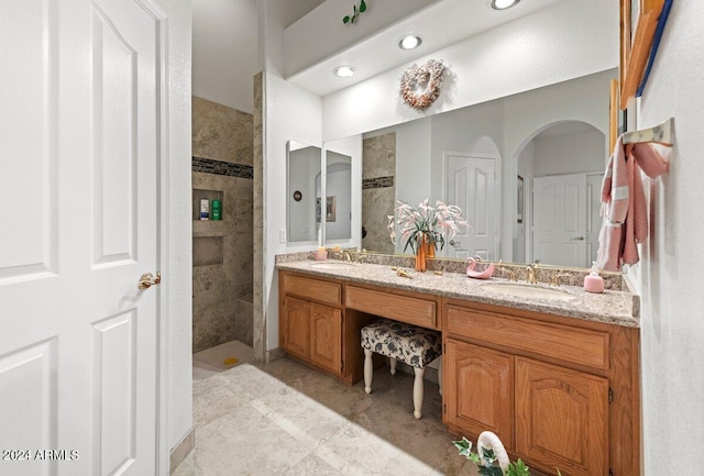 bathroom featuring vanity, tile patterned floors, and tiled shower