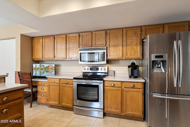 18780 N 94th Ave, Peoria, AZ 85382 - kitchen with stainless steel appliances, light countertops, brown cabinets, and light tile patterned floors