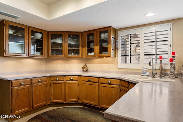 18780 N 94th Ave, Peoria, AZ 85382 - kitchen featuring light countertops, brown cabinets, glass insert cabinets, and recessed lighting