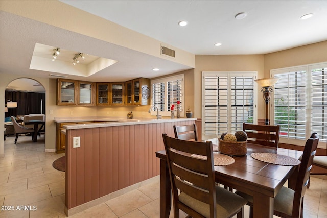 18780 N 94th Ave, Peoria, AZ 85382 - dining area with a tray ceiling, arched walkways, recessed lighting, bar with sink, and light tile patterned flooring
