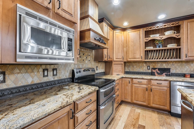 kitchen with light hardwood / wood-style flooring, premium range hood, stainless steel appliances, light stone countertops, and decorative backsplash