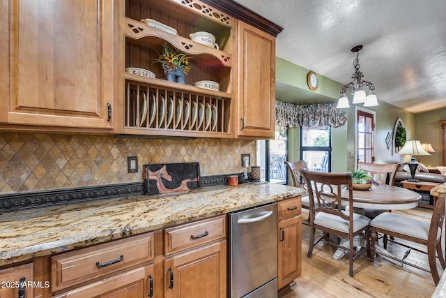 kitchen featuring light wood-type flooring, tasteful backsplash, light stone countertops, and pendant lighting