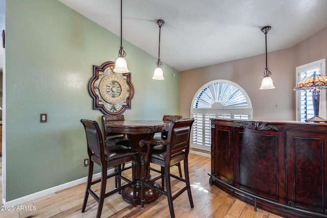 dining room with light hardwood / wood-style floors and lofted ceiling