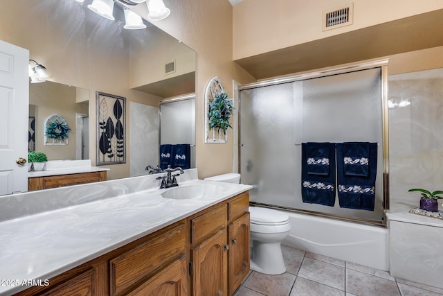 full bathroom featuring tile patterned floors, toilet, vanity, and combined bath / shower with glass door