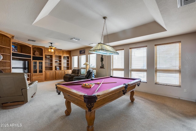 game room featuring a tray ceiling, light carpet, and a healthy amount of sunlight