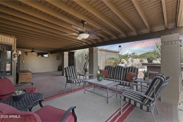 patio terrace at dusk featuring an outdoor living space and ceiling fan