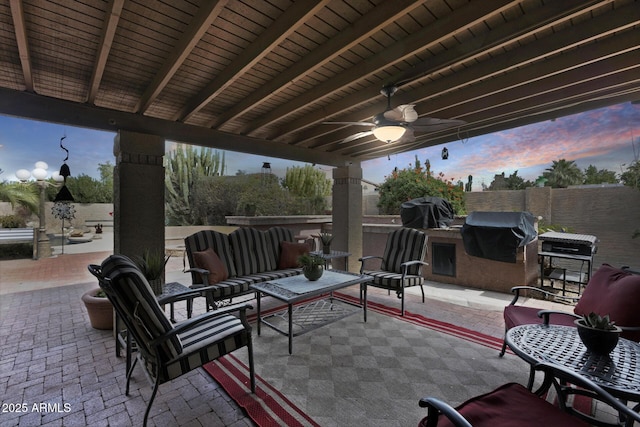 patio terrace at dusk with an outdoor living space, ceiling fan, a grill, and area for grilling