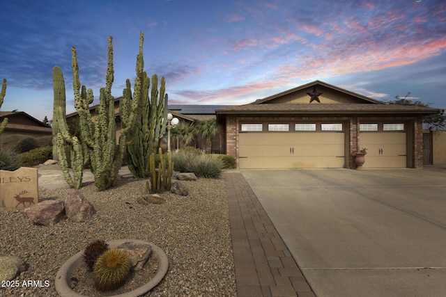 view of front of property featuring a garage and solar panels