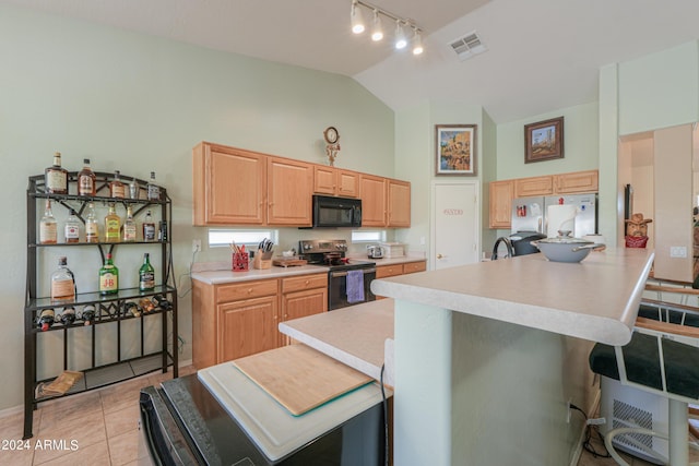 kitchen featuring sink, appliances with stainless steel finishes, a kitchen bar, light tile patterned flooring, and light brown cabinets