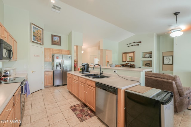 kitchen with sink, light tile patterned floors, stainless steel appliances, light brown cabinetry, and vaulted ceiling