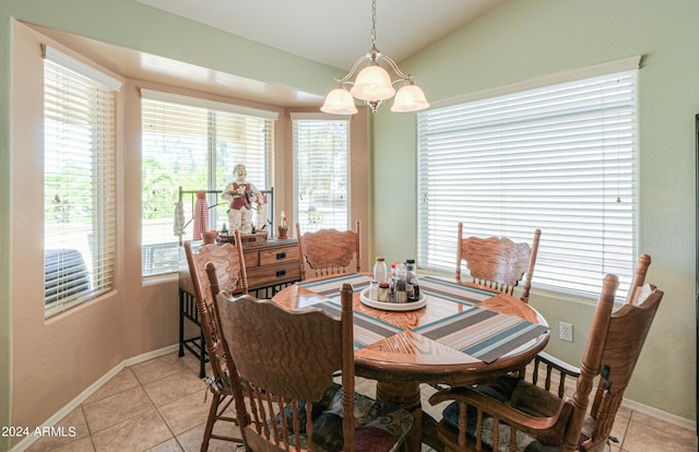 dining space featuring vaulted ceiling, light tile patterned floors, and an inviting chandelier