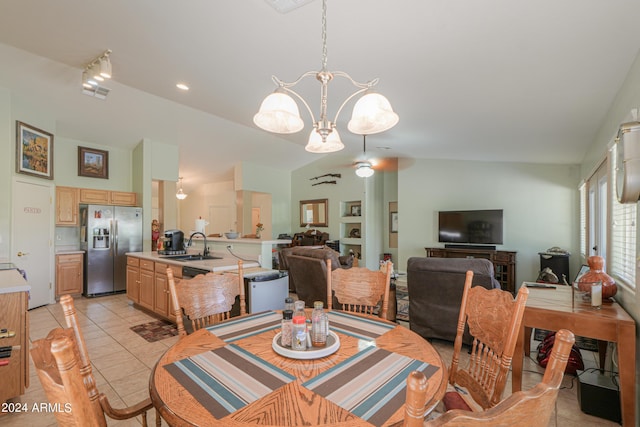 tiled dining area featuring sink, a notable chandelier, and vaulted ceiling