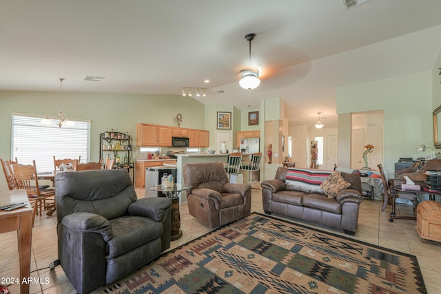 tiled living room featuring ceiling fan and vaulted ceiling