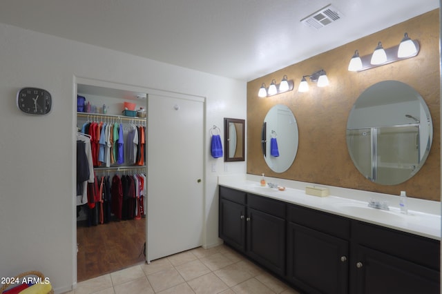 bathroom featuring tile patterned flooring, vanity, and a shower with door