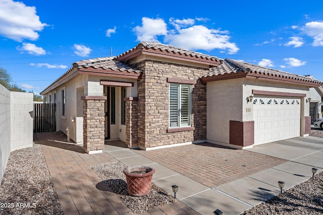 view of front of home featuring fence, a tile roof, stucco siding, driveway, and an attached garage