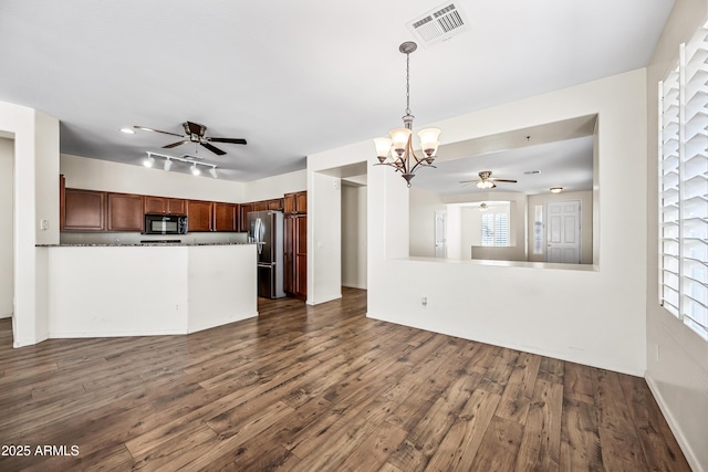 kitchen with kitchen peninsula, pendant lighting, dark hardwood / wood-style flooring, and stainless steel refrigerator