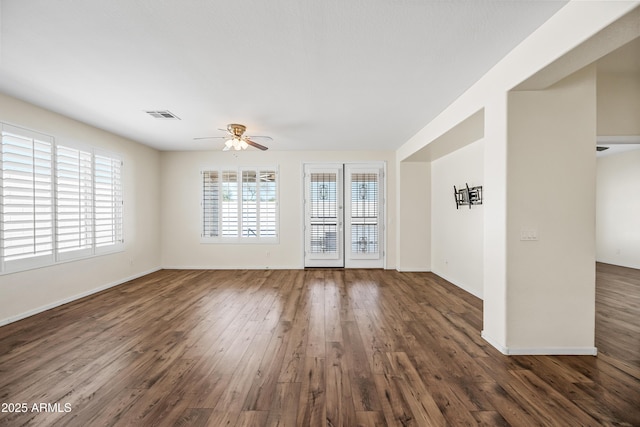 unfurnished room featuring visible vents, baseboards, wood finished floors, and a ceiling fan