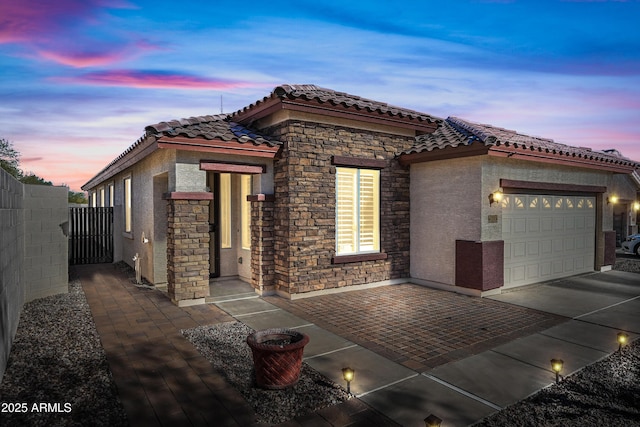 view of front facade featuring stucco siding, fence, concrete driveway, a garage, and a tiled roof