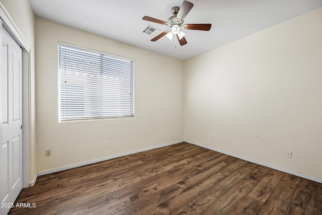 unfurnished room featuring a ceiling fan, wood finished floors, visible vents, and baseboards