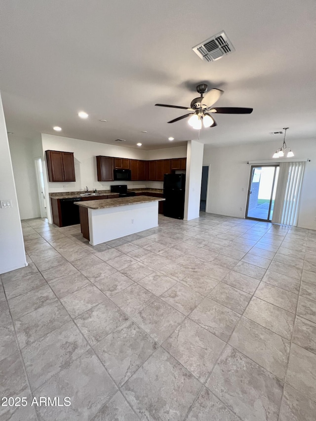 kitchen featuring visible vents, black appliances, a kitchen island, open floor plan, and dark brown cabinetry