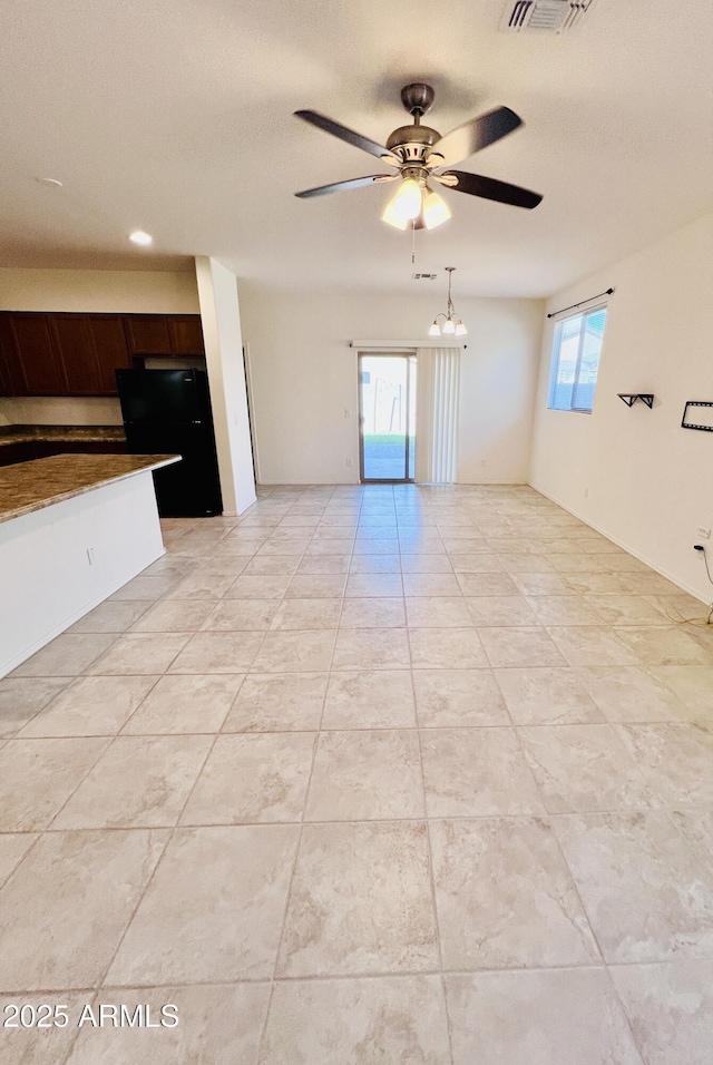 unfurnished living room featuring light tile patterned flooring, visible vents, and ceiling fan