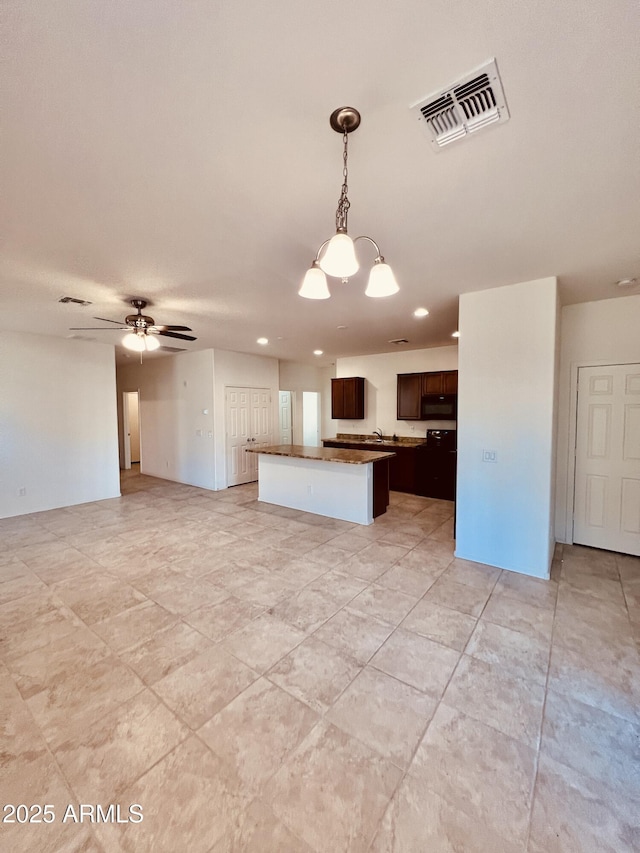 kitchen with open floor plan, visible vents, and a center island