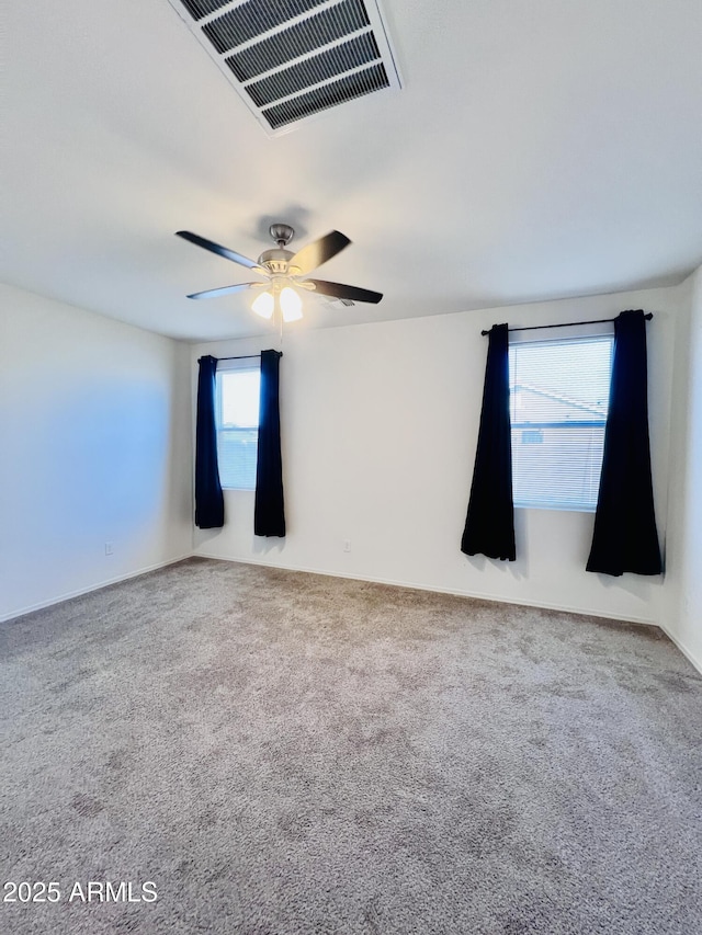 carpeted empty room with visible vents and ceiling fan