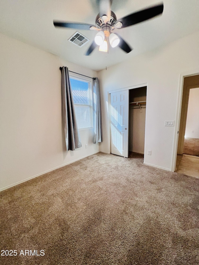 unfurnished bedroom with visible vents, carpet floors, a closet, and a ceiling fan